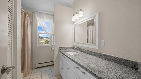 a bathroom with a granite countertop sink and a mirror