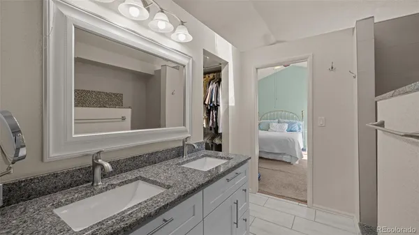 a bathroom with a granite countertop sink and a mirror