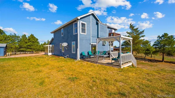 a view of a house with backyard and sitting area