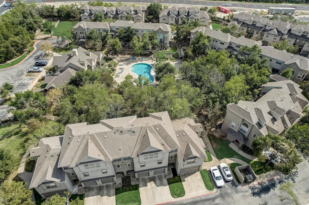 11203 Ranch Road 2222, Unit 2404 Austin, TX 78732 - Photo 26 of 28 Community setting featuring multiple multi-story residential buildings, ample paved parking areas, and mature trees