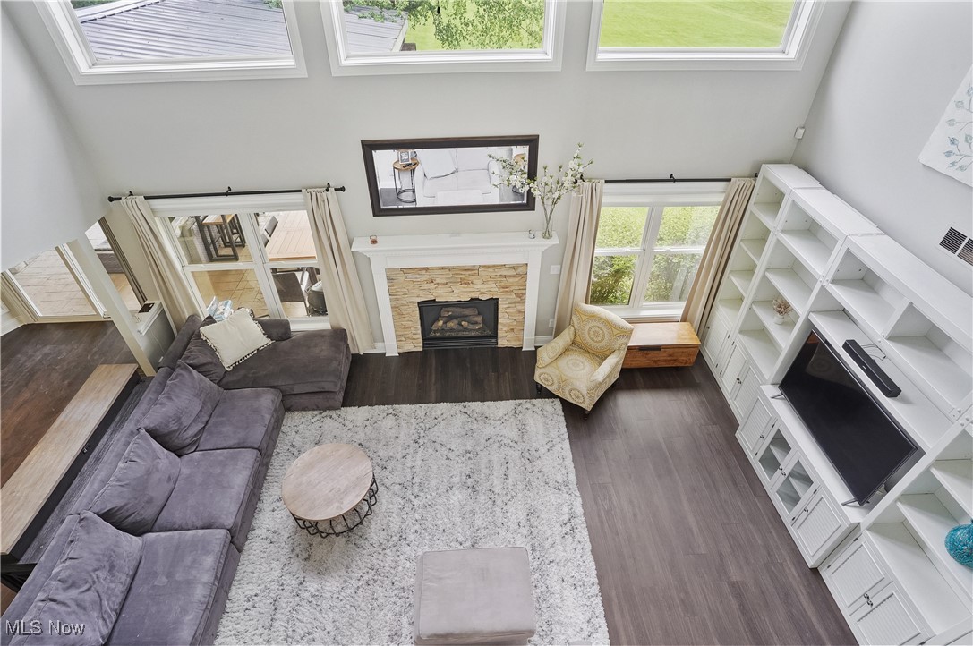 7305 Alexander Road Painesville, OH 44077 - Photo 4 of 50 Living area with new LVT floors, a stone fireplace, and a towering ceiling