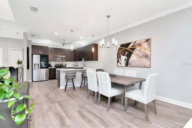 a living room with stainless steel appliances kitchen island furniture and a wooden floor