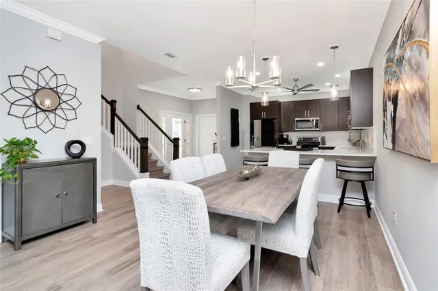 a open kitchen with granite countertop a table chairs a sink dishwasher stove and cabinets with wooden floor