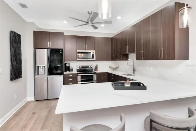 a kitchen with kitchen island a sink stainless steel appliances and cabinets