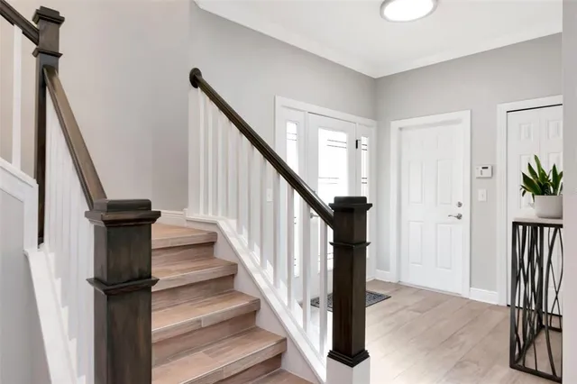 a view of staircase with wooden floor and a chandelier