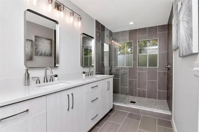 a bathroom with a double vanity sink mirror and shower
