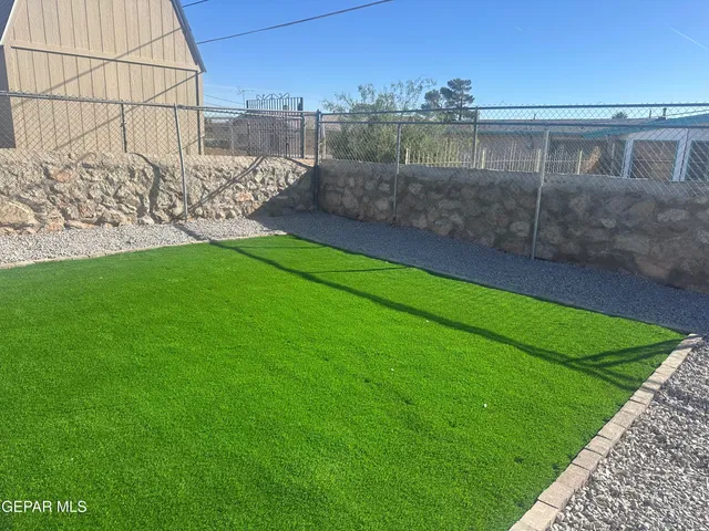 a view of a yard with a wooden fence