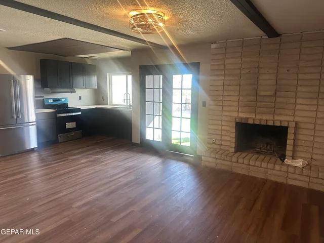 a living room with hard wood floors and a fireplace
