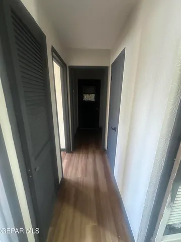 a view of a hallway with wooden floor and stairs