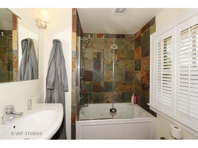 227 Addison Road Riverside, IL 60546 - Photo 8 of 21 a bathroom with a tub sink vanity and mirror