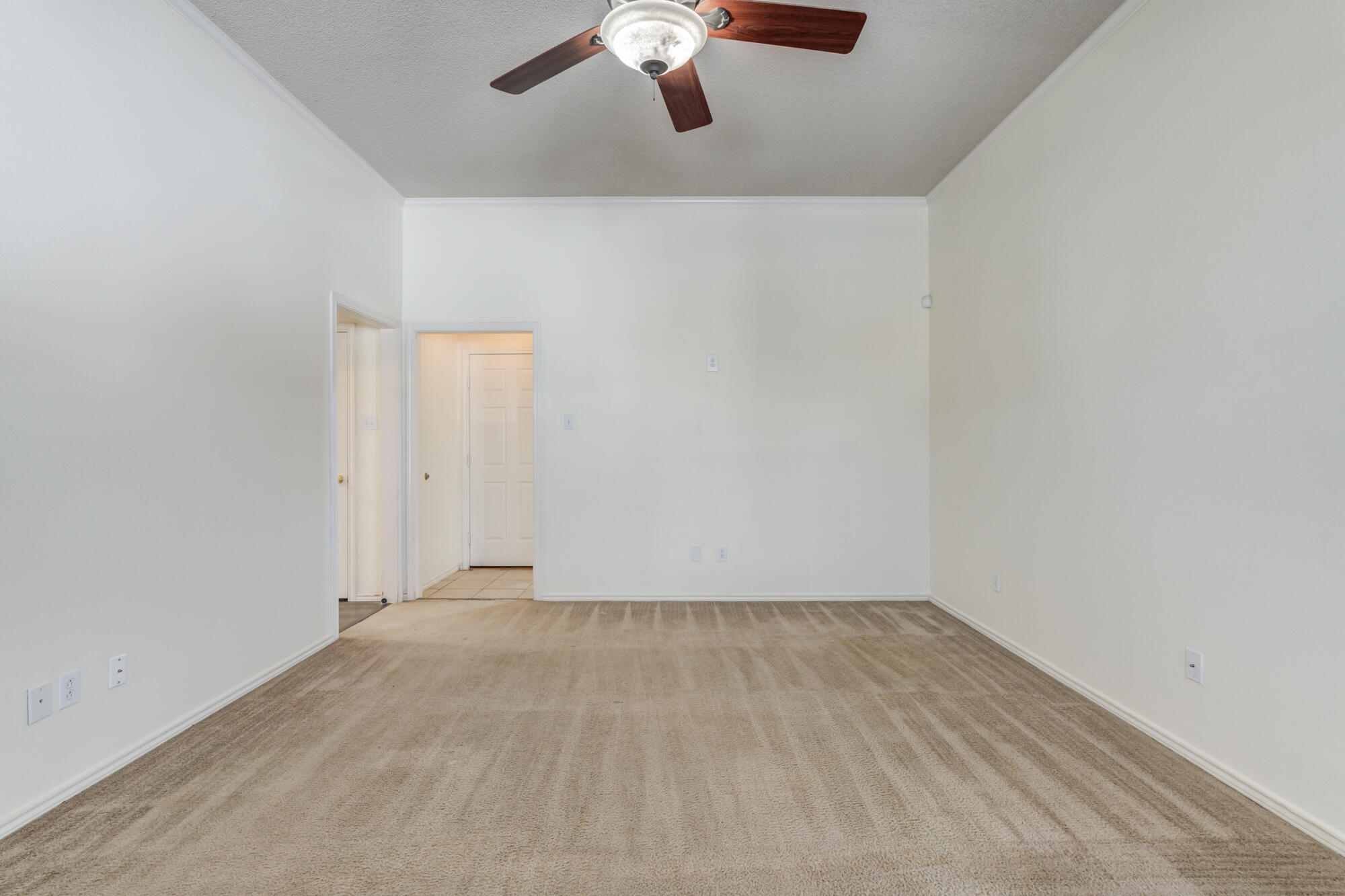 1903 77th Street Lubbock, TX 79423 - Photo 11 of 30 an empty room with a ceiling fan and carpet