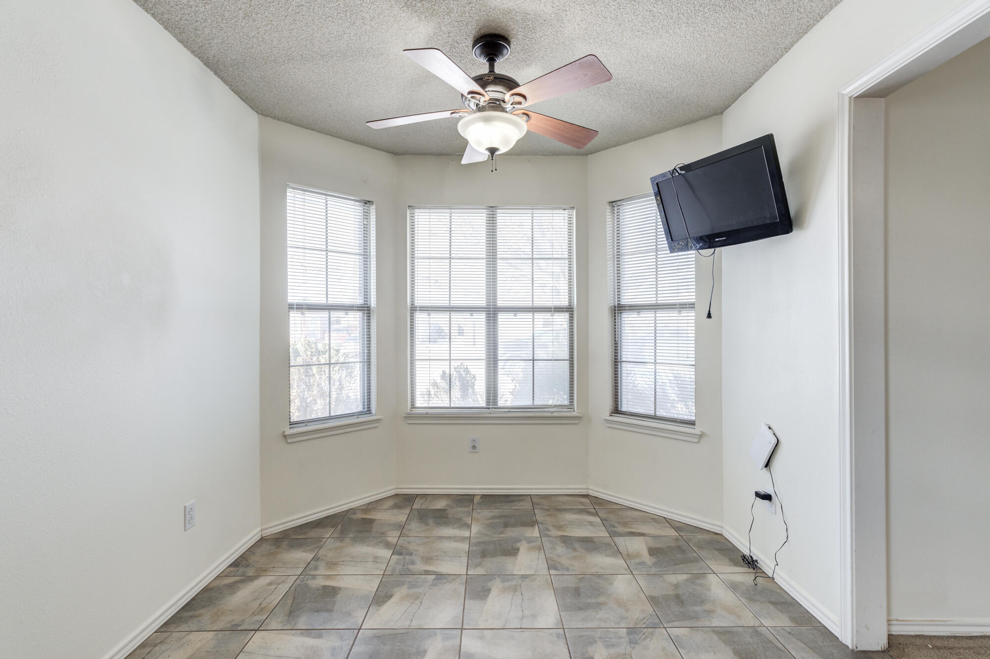 1903 77th Street Lubbock, TX 79423 - Photo 12 of 30 an empty room with windows and fan