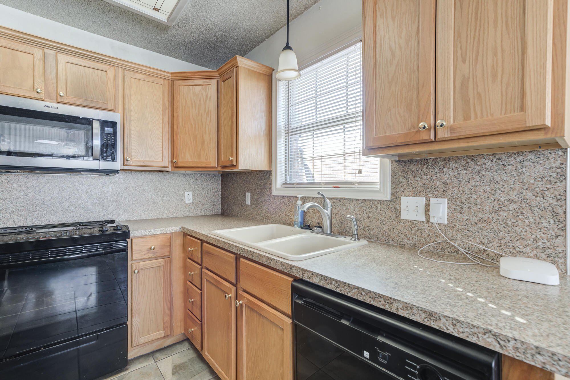 1903 77th Street Lubbock, TX 79423 - Photo 13 of 30 a kitchen with granite countertop a sink stainless steel appliances and cabinets