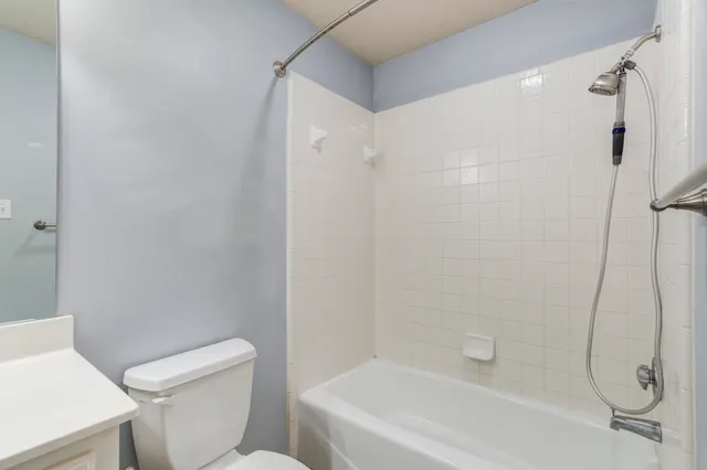 a white bath tub sitting next to a white toilet and sink