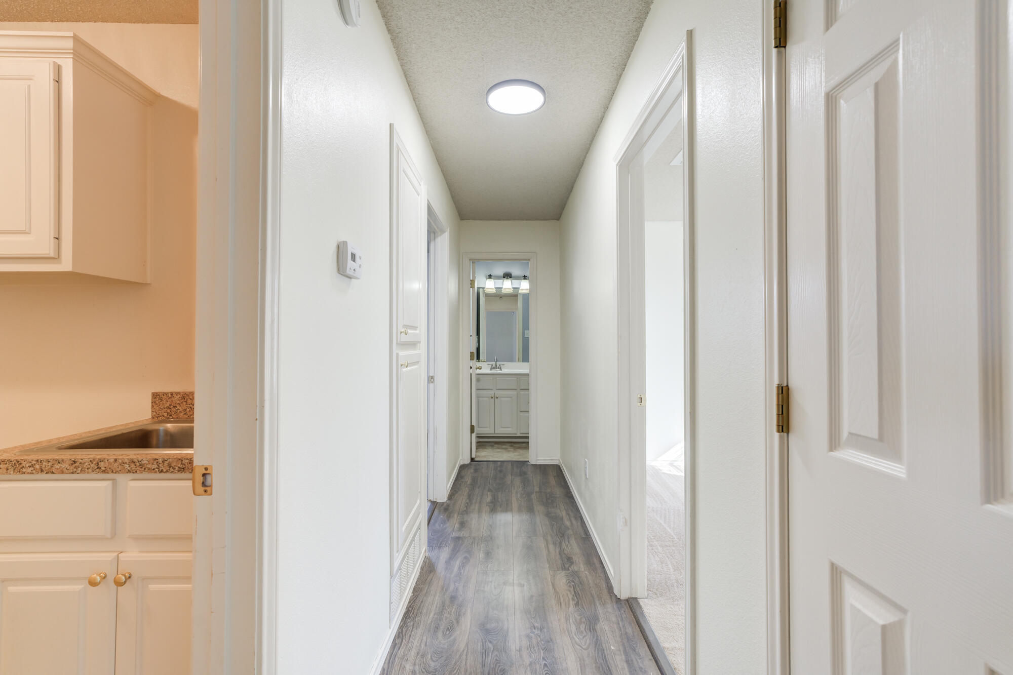 1903 77th Street Lubbock, TX 79423 - Photo 26 of 30 a view of a hallway with wooden floor and staircase