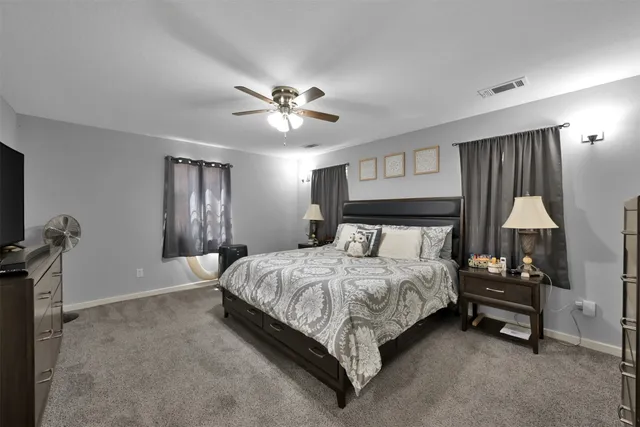 a bedroom with a bed a chandelier and a flat screen tv