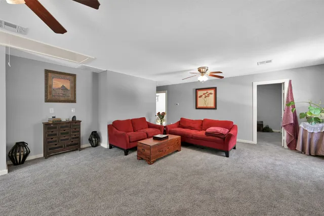 a living room with furniture a flat screen tv and a chandelier