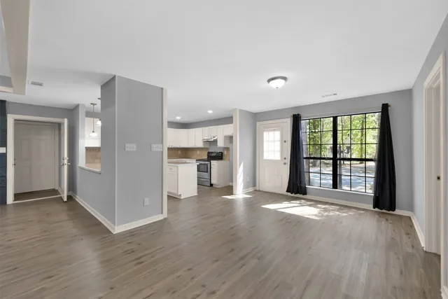 an empty room with windows and fireplace