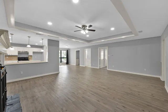 a view of an empty room with a chandelier fan