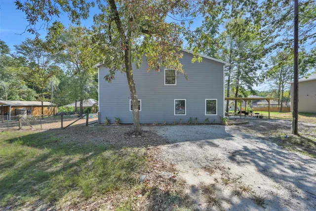 a view of a yard with a house and a large tree