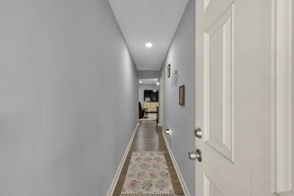 a view of a hallway with wooden floor and staircase