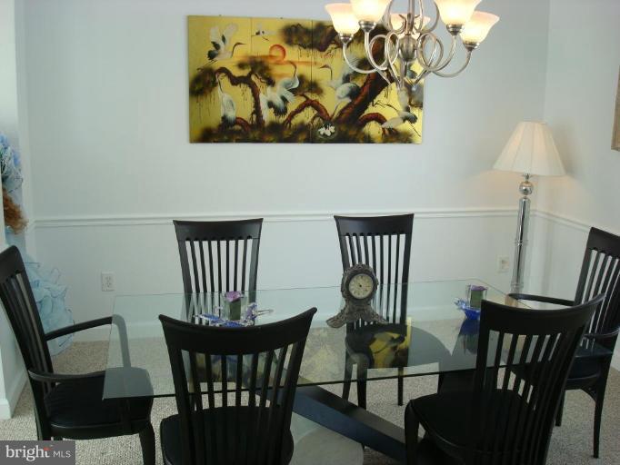 18810 Severn Road Gaithersburg, MD 20879 - Photo 3 of 28 a view of a dining room with furniture a chandelier and wooden floor