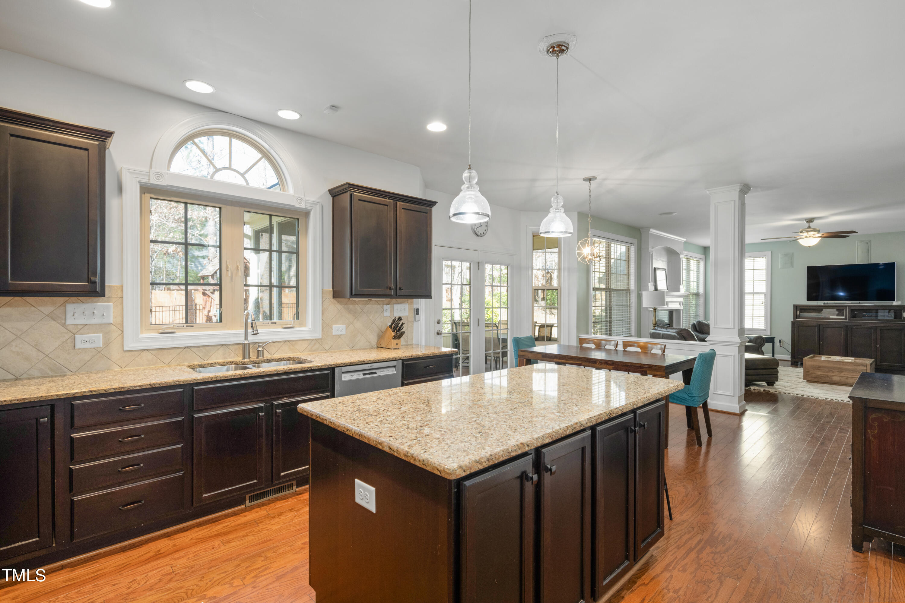 3020 Red Grape Drive Raleigh, NC 27607 - Photo 14 of 37 a kitchen with a stove a sink a center island and a wooden floor