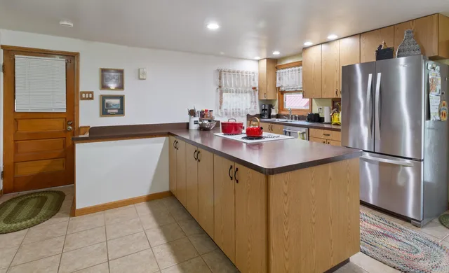 a kitchen with a sink refrigerator and cabinets