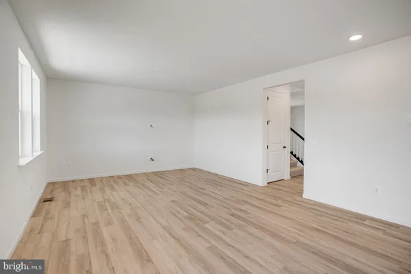 a large white kitchen with wooden floor and a sink
