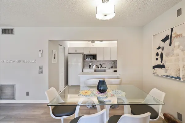 a kitchen with stainless steel appliances kitchen island granite countertop a table and chairs