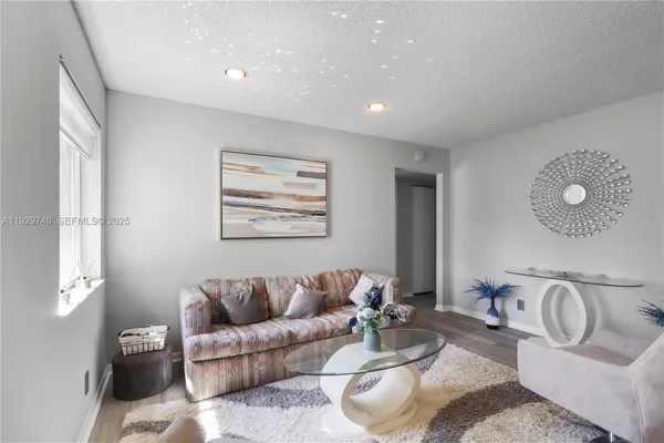a living room with furniture a couch and wooden floor