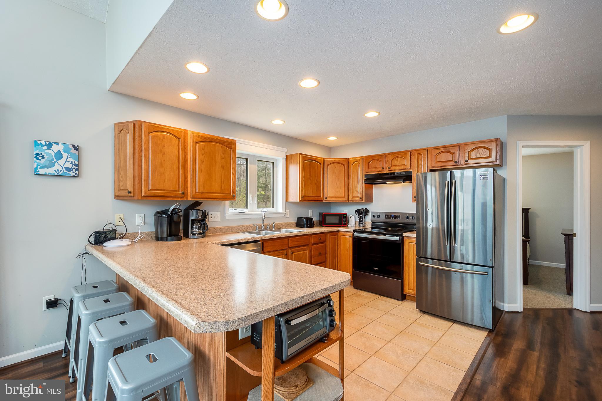 638 Glendale Road Oakland, MD 21550 - Photo 12 of 56 a kitchen with stainless steel appliances granite countertop a refrigerator a sink dishwasher and a stove with wooden floor