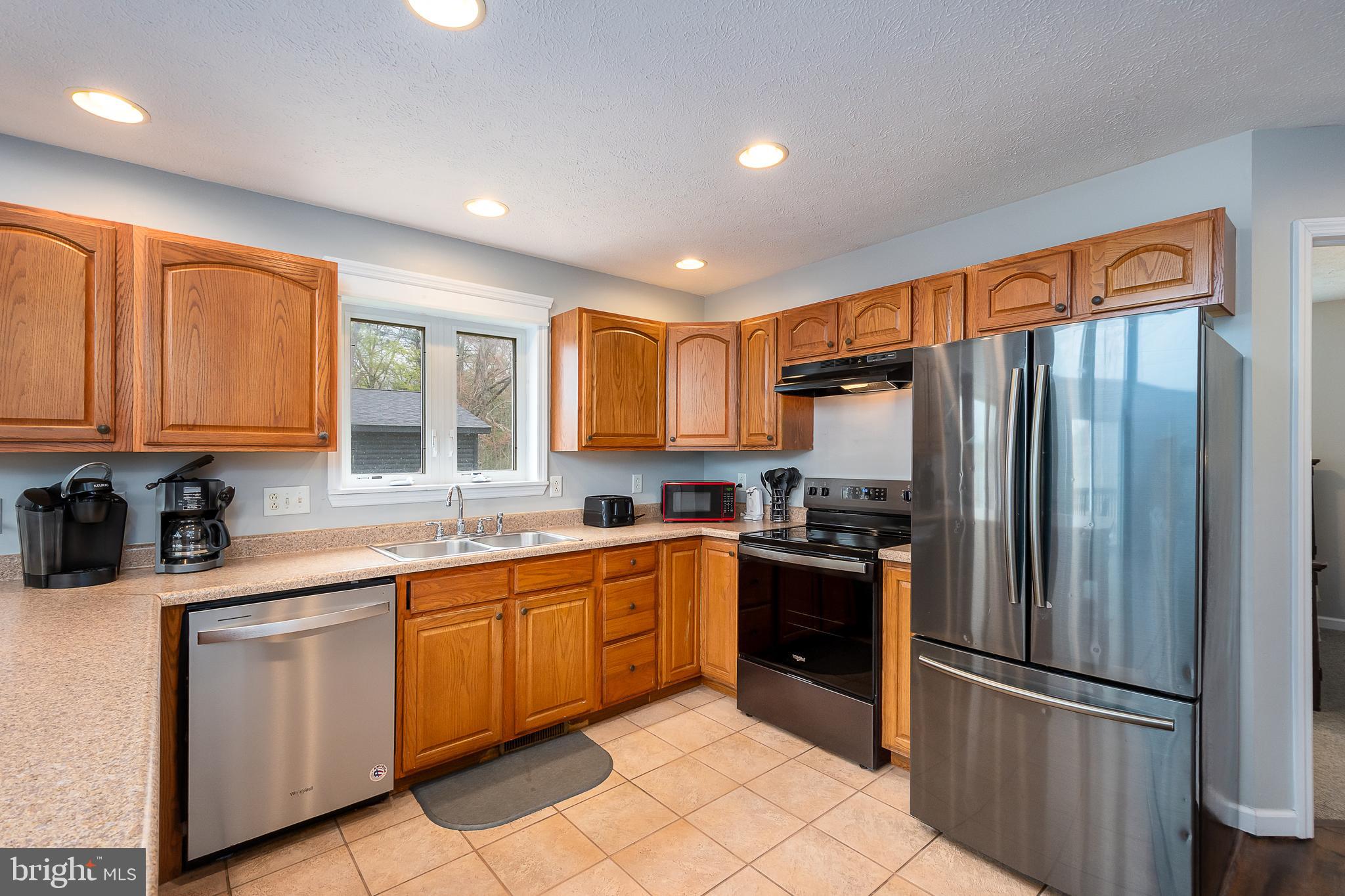 638 Glendale Road Oakland, MD 21550 - Photo 13 of 56 a kitchen with stainless steel appliances granite countertop a refrigerator sink and cabinets