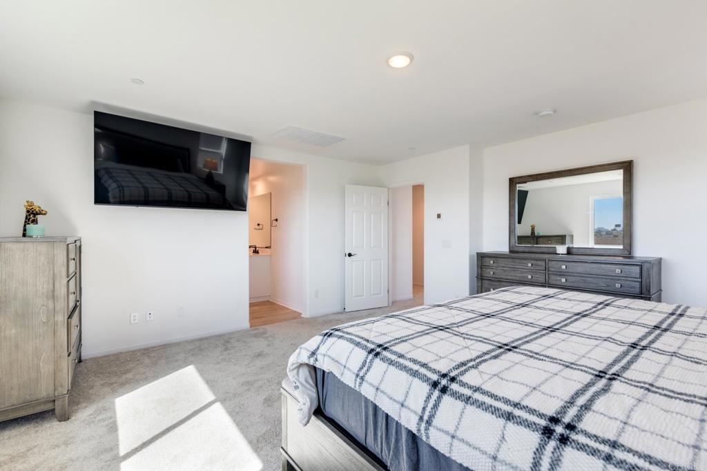 30343 Singer Lane Menifee, CA 92584 - Photo 15 of 24 a bedroom with a large bed and a flat screen tv