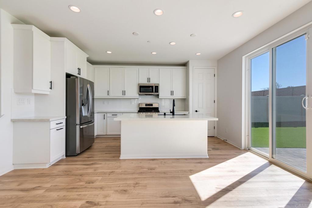 30343 Singer Lane Menifee, CA 92584 - Photo 3 of 24 a view of kitchen with stainless steel appliances refrigerator oven microwave and stove