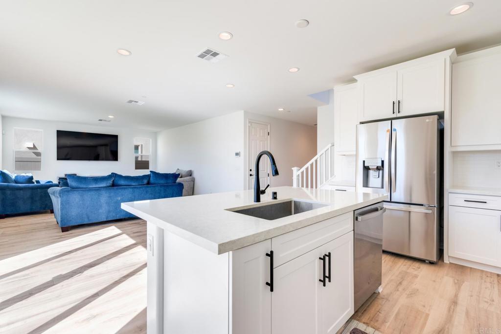 30343 Singer Lane Menifee, CA 92584 - Photo 4 of 24 a kitchen with stainless steel appliances granite countertop a sink stove and refrigerator