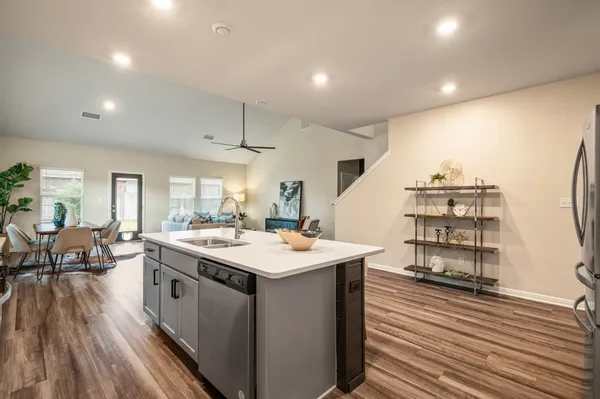 a kitchen with stainless steel appliances granite countertop a table chairs sink and cabinets