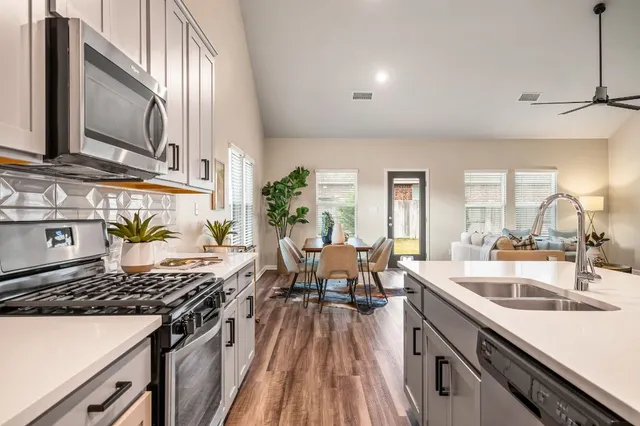 a open kitchen with a sink stove and wooden floor
