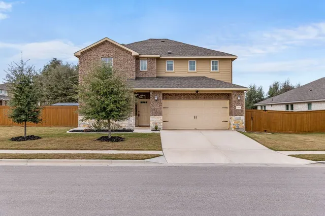 a front view of a house with a yard and garage