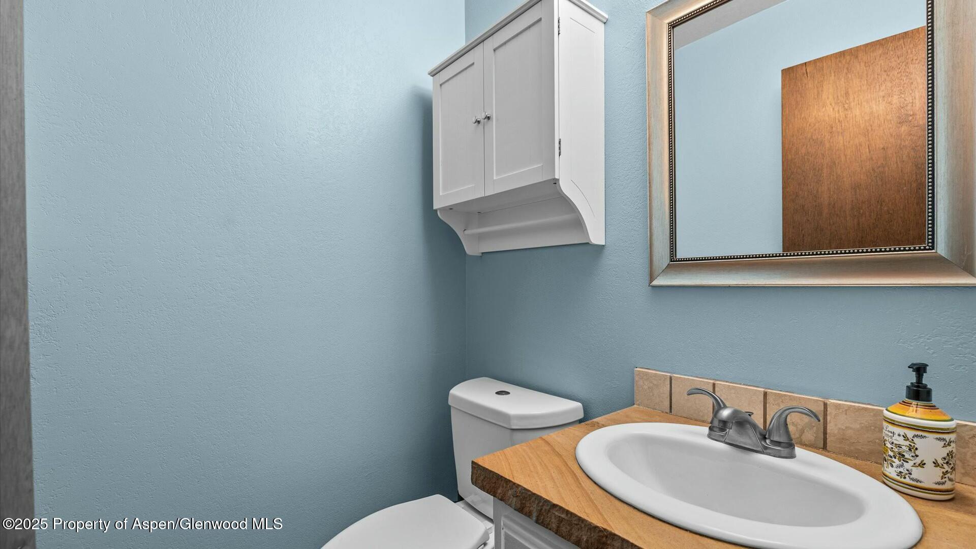 1201 Fir Avenue Rifle, CO 81650 - Photo 20 of 25 a bathroom with a toilet a sink and mirror