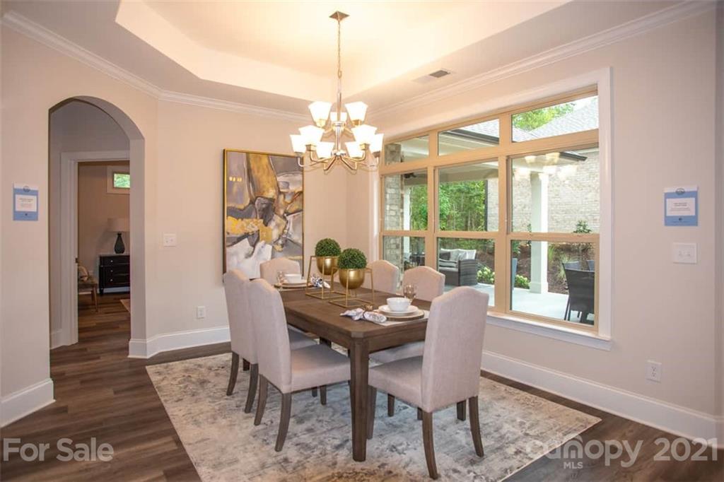 2023 New Style Way, Unit 24 Tega Cay, SC 29708 - Photo 12 of 18 a dining room with furniture a chandelier and wooden floor