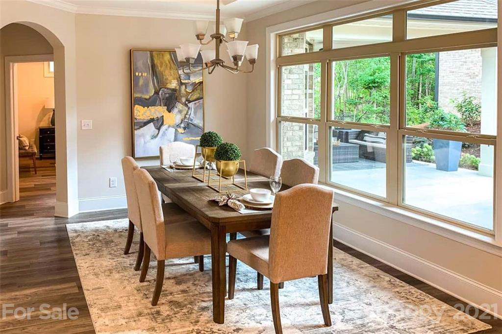 2023 New Style Way, Unit 24 Tega Cay, SC 29708 - Photo 13 of 18 a dining room with furniture a chandelier and wooden floor