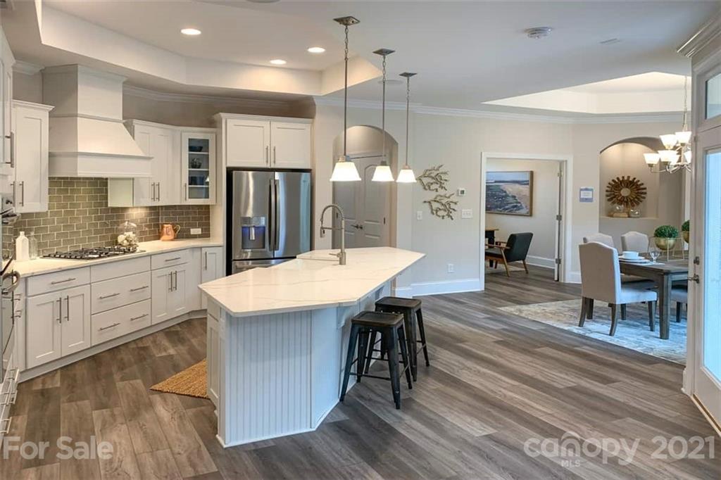 2023 New Style Way, Unit 24 Tega Cay, SC 29708 - Photo 7 of 18 a kitchen with a table chairs refrigerator and microwave