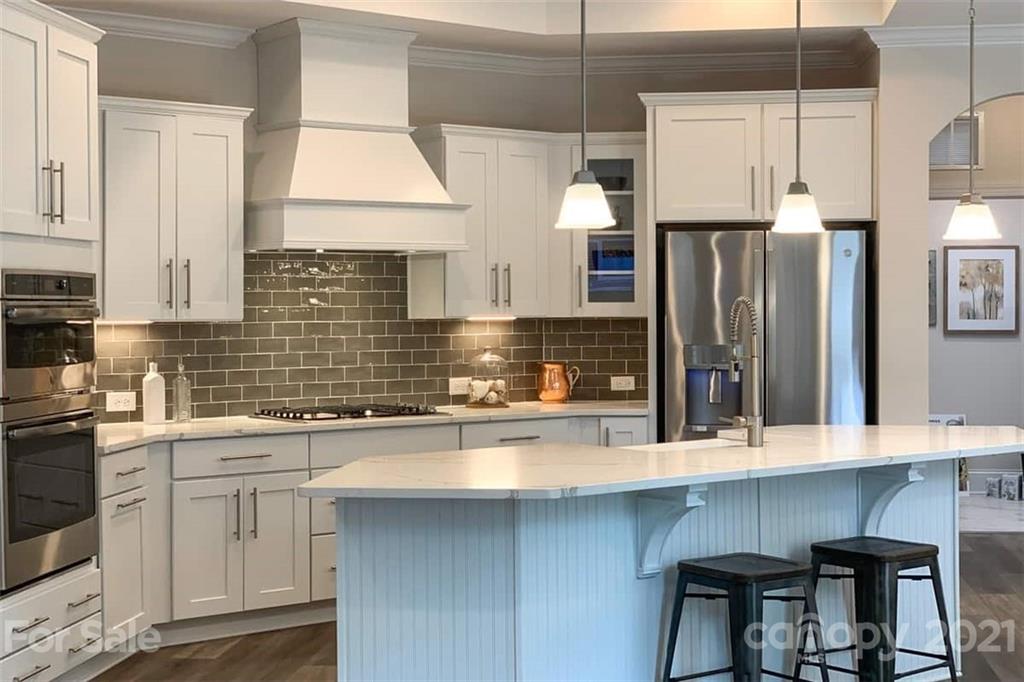 2023 New Style Way, Unit 24 Tega Cay, SC 29708 - Photo 8 of 18 a kitchen with stainless steel appliances a sink a stove a refrigerator and cabinets