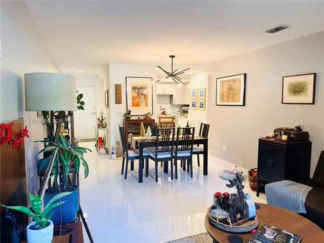 a dining room with furniture potted plants and a wooden floor