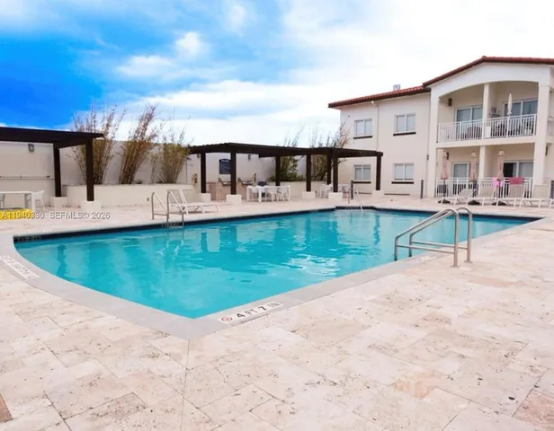 a view of a house with pool fire pit a patio and a yard