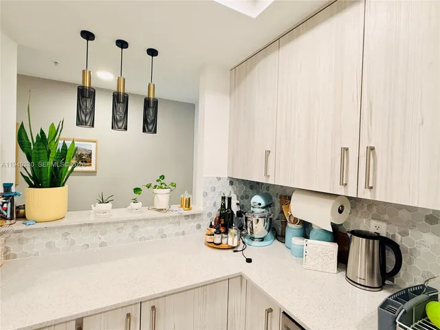 a kitchen with a sink a potted plant and cabinets