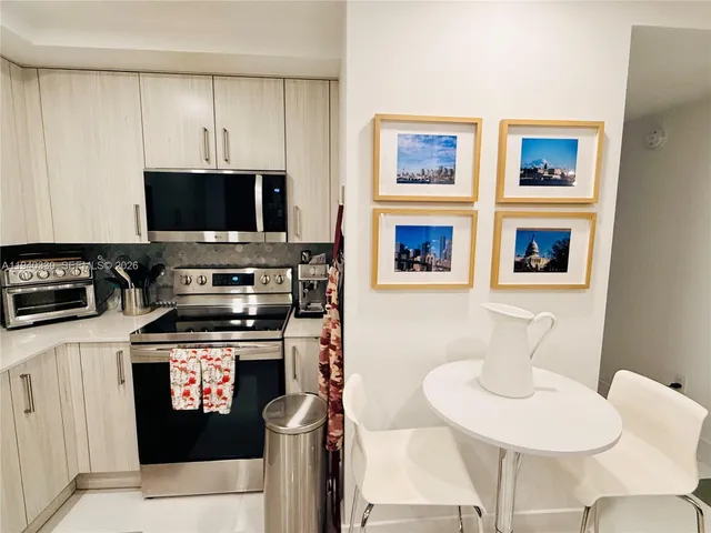 a kitchen with stainless steel appliances a stove a sink and a microwave