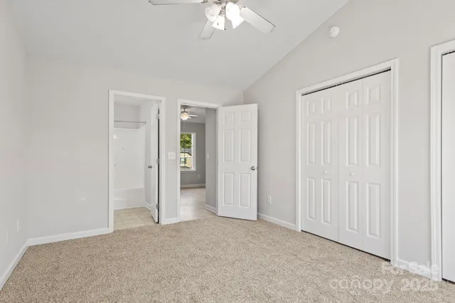 an empty room with a ceiling fan and a bathroom