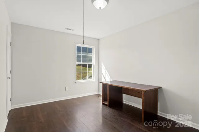 a view of room with window and wooden floor